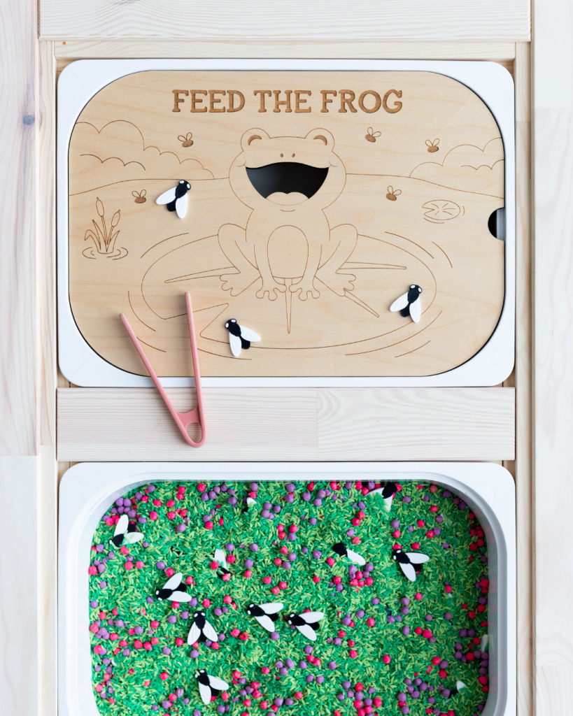 Feed the Frog laser engraved wood sensory tray with bug loose parts and pink tweezers, fitting an IKEA Trofast bin.