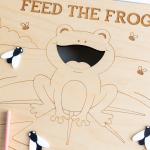 Feed the Frog laser engraved wood sensory tray with bug loose parts and pink tweezers, fitting an IKEA Trofast bin.